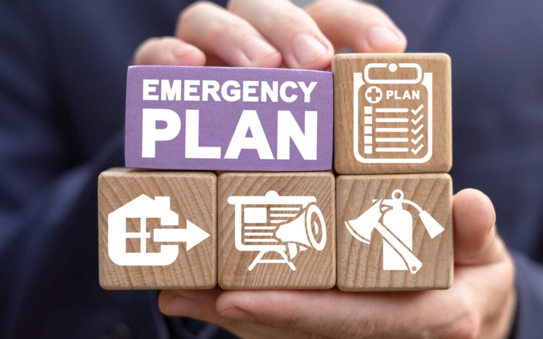 An image of someone holding blocks that say emergency plan, with images of a fire extinguisher, checklist, exit route and plan.